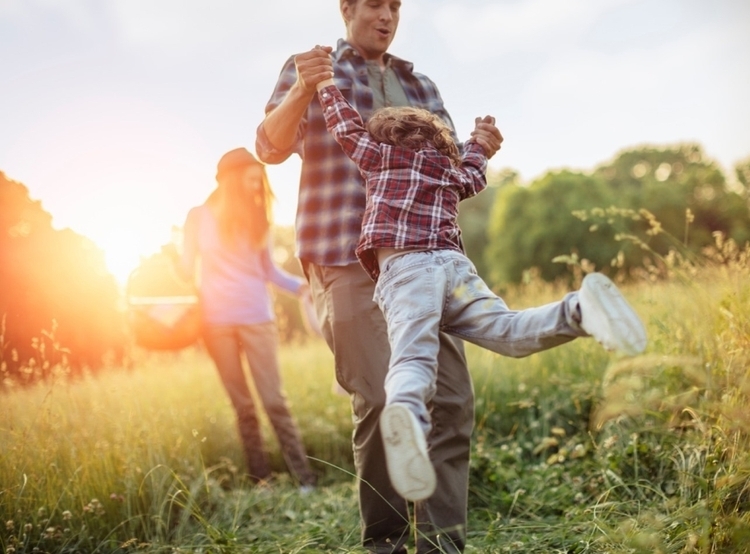 man swinging child in a circle